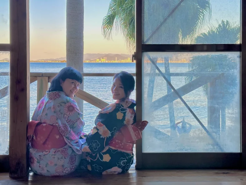 Two girls at a window in tradizional japanese dress in Fukuoka, Japan